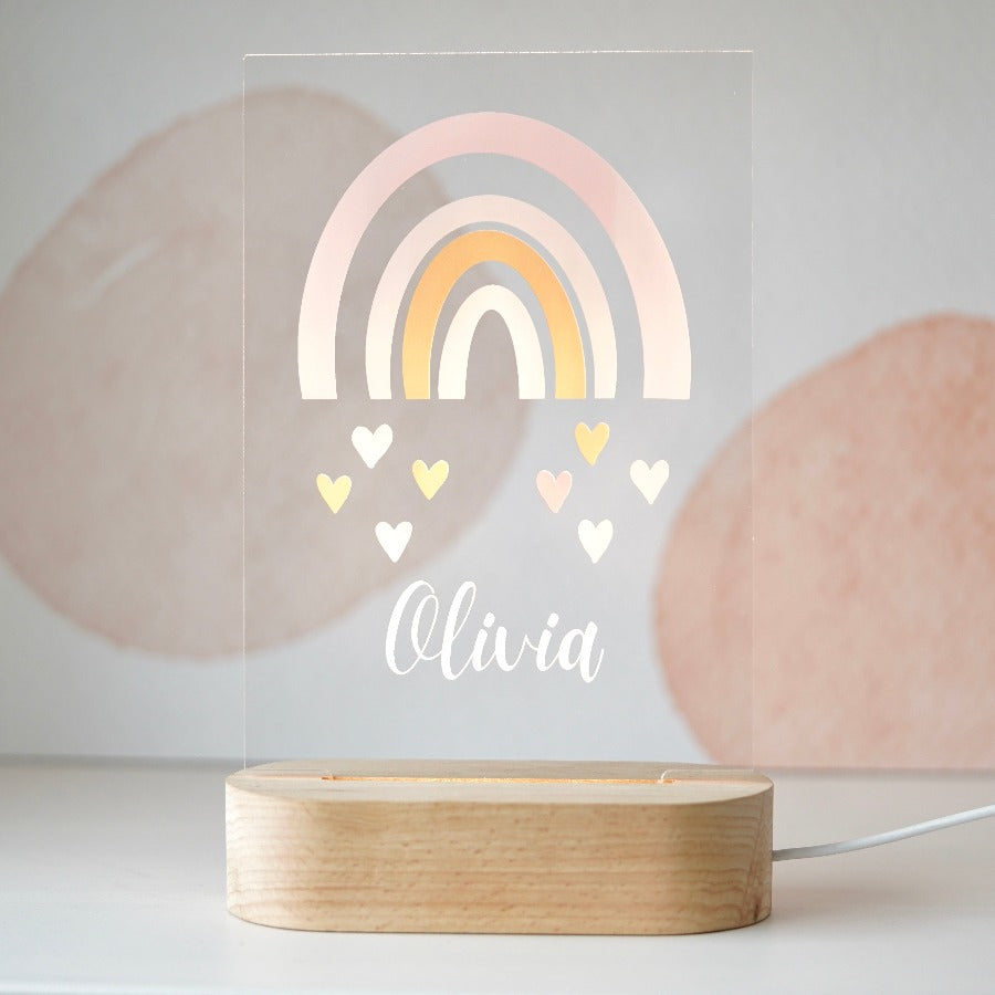 Placa iluminada para niños con dibujo de arcoíris y nombre personalizado. Añade un toque de magia a la habitación del niño o niña. Dimensiones: 135x210x3mm.