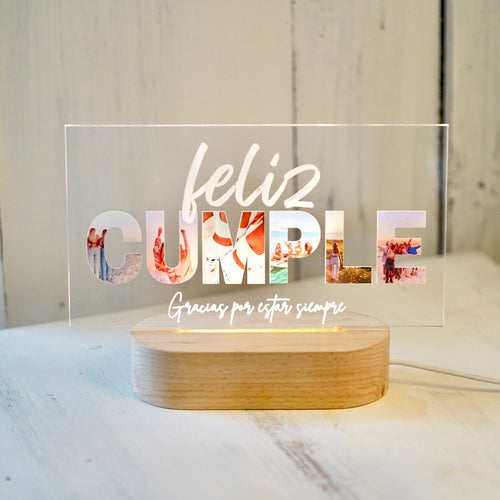 Placa horizontal con base de lámpara, personalizada con fotos dentro de las letras de 'CUMPLE' y una dedicatoria única. Ideal como regalo de cumpleaños. Dimensiones: 135x210x3mm.